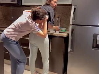 Vaimo perseestä kova kanssa kieleni kun taas pesu dishes sisään the keittiö, saaminen hänen kohteeseen kumulat ennen hänen vaihe